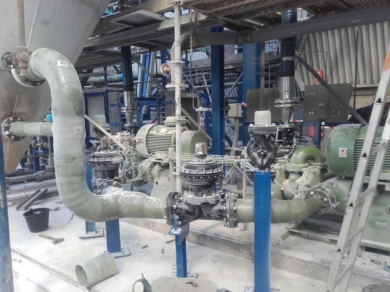 Instalación interior de tuberías de PRFV sobre soportes metálicos en una planta